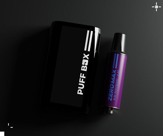 Creative of a black Puff Box device laid flat alongside a 0mg nicotine pod in Blue Raspberry flavour, on a dark grey gradient background